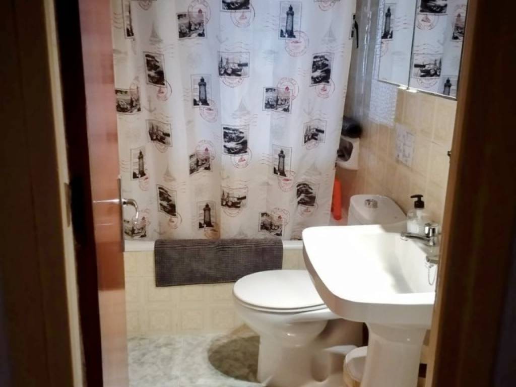 Baño con bañera y ventana al porche trasero