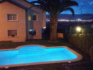 Vista nocturna de piscina y ría iluminadas