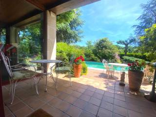 Piscina con zona de porche con toldo